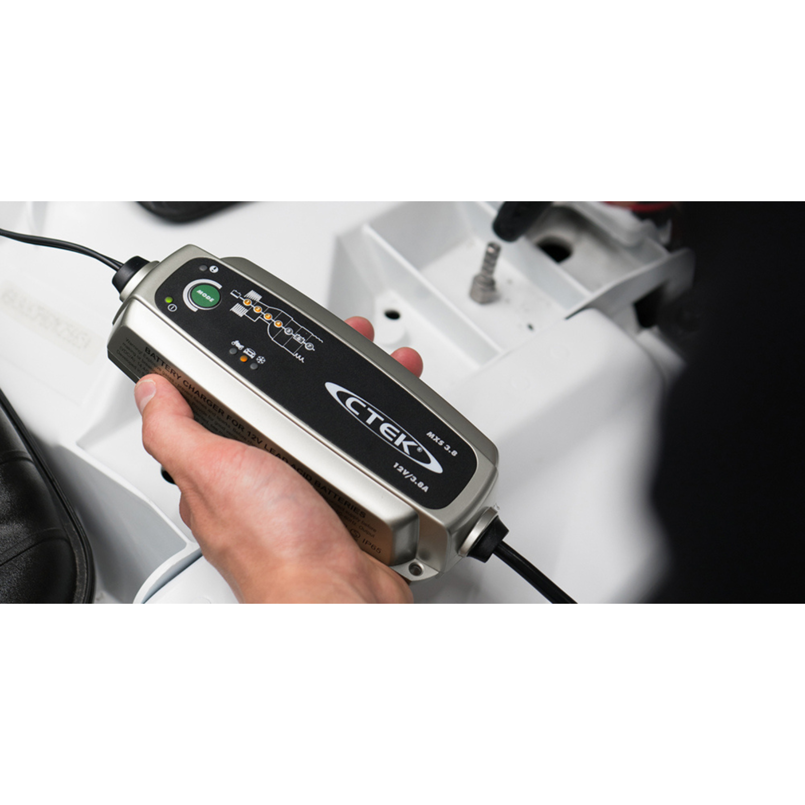 Hand holding CTEK 12V battery charger for campervan, off-grid, and marine power systems