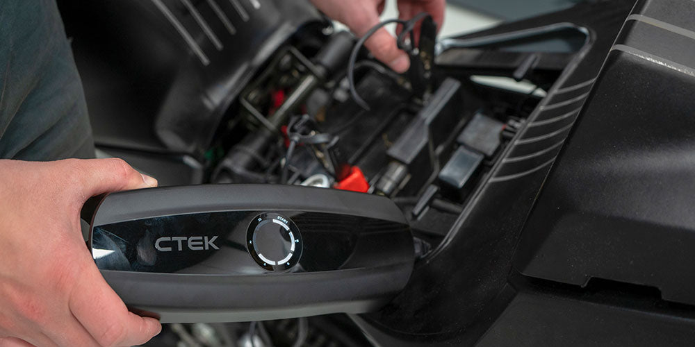 Person using CTEK battery charger to charge a vehicle or campervan battery