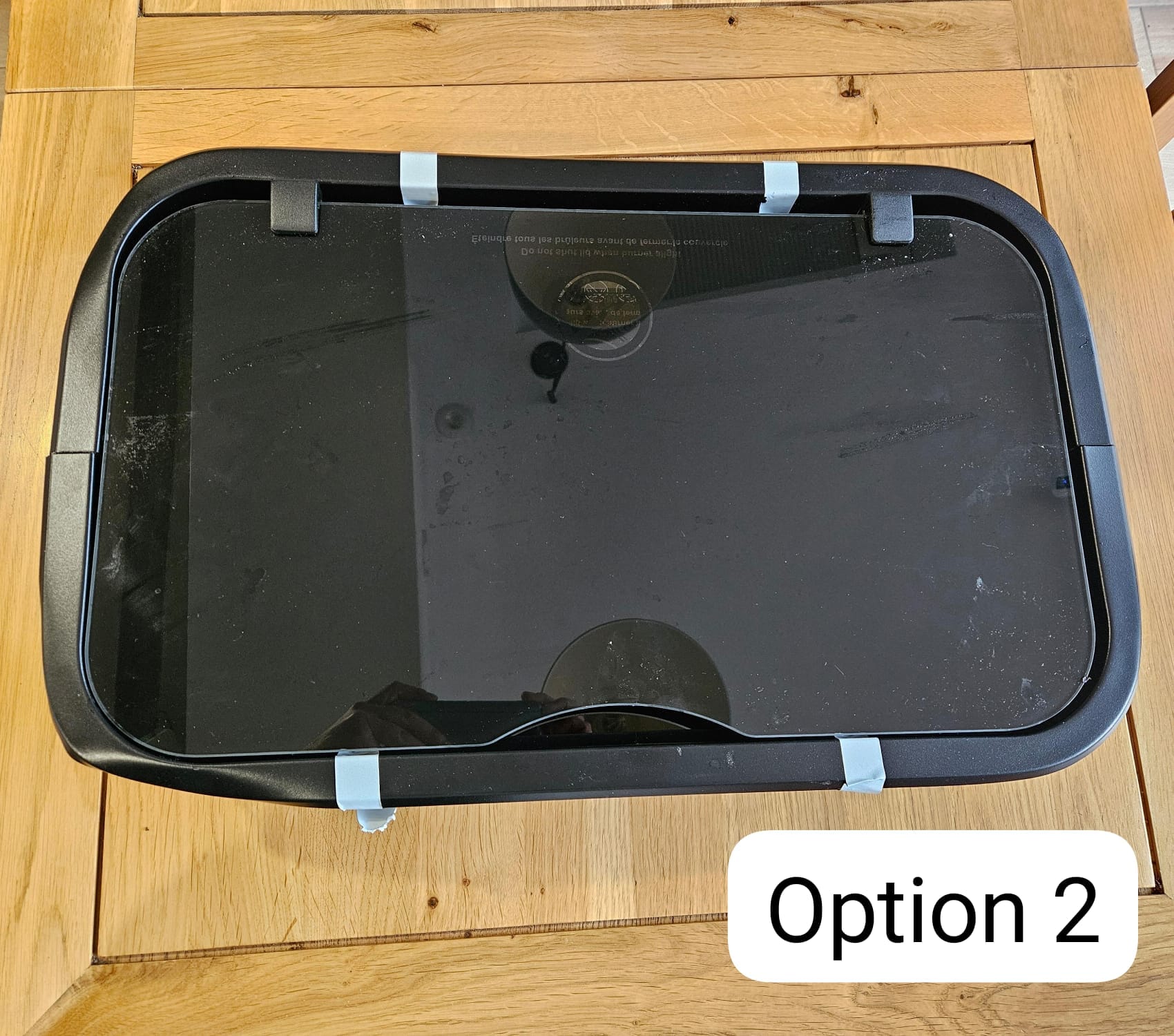 Black campervan window with rounded corners on wooden table, labeled Option 2